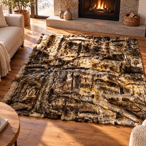May include: A rectangular area rug featuring a patchwork design of faux fur in shades of brown, black, and cream. The rug has a thick, textured pile with visible seams between the rectangular panels, creating a multi-tonal appearance.