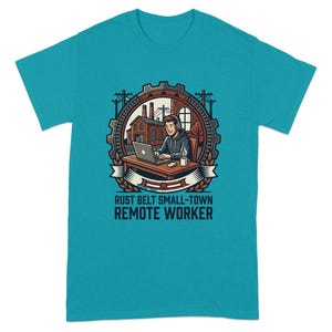 Puede incluir: Camiseta turquesa con un gráfico de una persona trabajando de forma remota en un portátil. El diseño incluye un engranaje, una fábrica y el texto "RUST BELT SMALL-TOWN REMOTE WORKER". El diseño es en tonos marrones, rojos y blancos.
