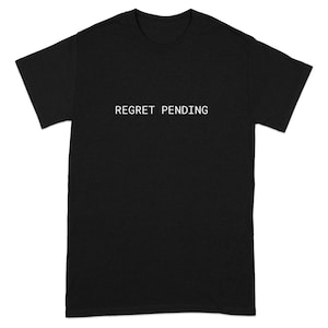 May include: Black t-shirt with the text "REGRET PENDING" in white, centered on the chest. The shirt has short sleeves and a crew neck.