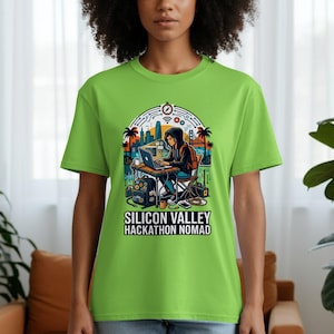 May include: A lime green t-shirt featuring a colorful graphic of a person working on a laptop in front of a cityscape. The text "SILICON VALLEY HACKATHON NOMAD" is printed below the graphic.