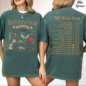 A woman wearing a green t-shirt with a graphic design and text on the back.