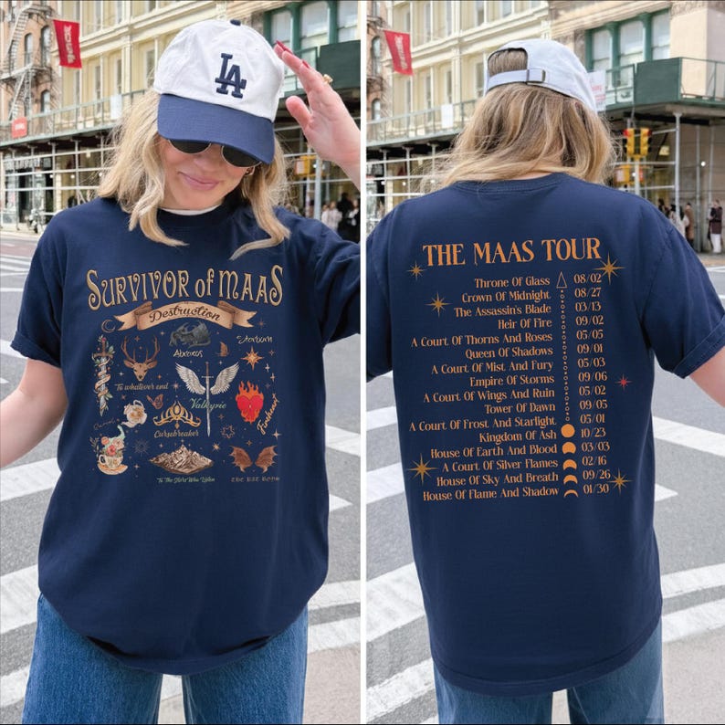 A woman wearing a blue t-shirt with a graphic design and text, standing on a city street.