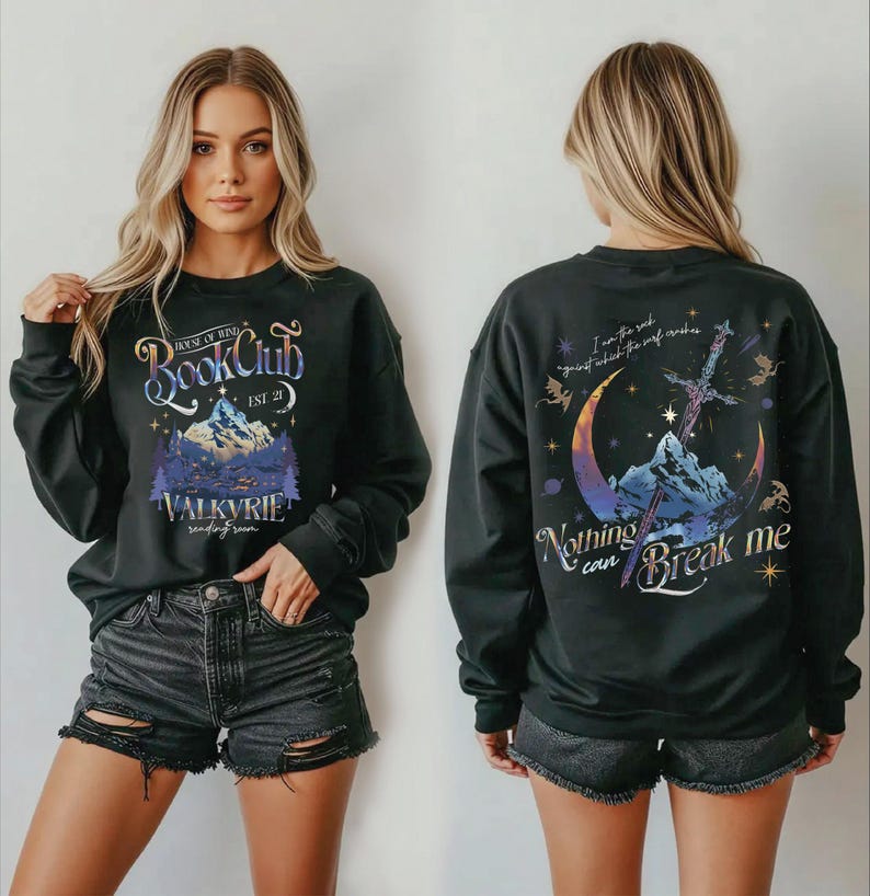 A woman wearing a black sweatshirt with a graphic design on the front and back.