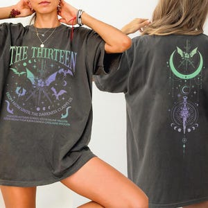 A person wearing a black t-shirt with a graphic design on the front and back.