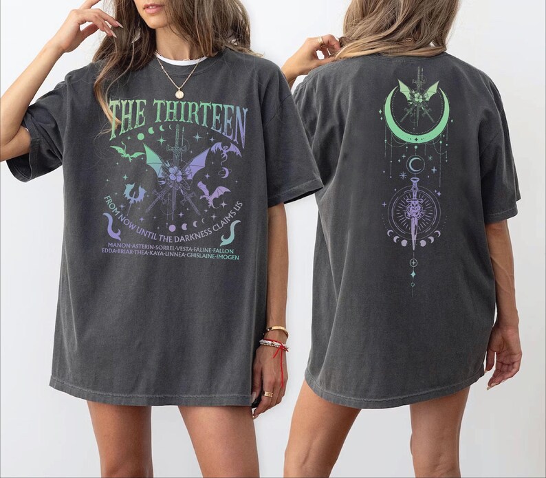 a woman wearing a gray t-shirt with a graphic design on the front and back.