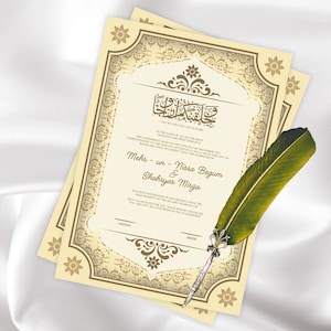 May include: Two beige wedding invitations with ornate floral borders and Arabic calligraphy. A green feather quill pen rests on the invitations. The text includes names and dates, indicating a marriage ceremony.