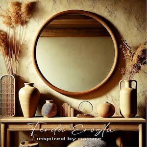Round oak wood mirror in a rustic interior with warm earthy tones, surrounded by ceramic vases and natural fiber decor pieces.