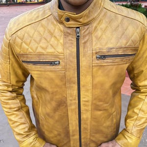 K&ouml;nnte beinhalten: Senfgelbe Lederjacke mit Steppdesign an den Schultern und zwei Brusttaschen mit Rei&szlig;verschluss. Die Jacke hat einen Stehkragen und einen durchgehenden Rei&szlig;verschluss. Das Leder hat ein Used-Look-Aussehen.
