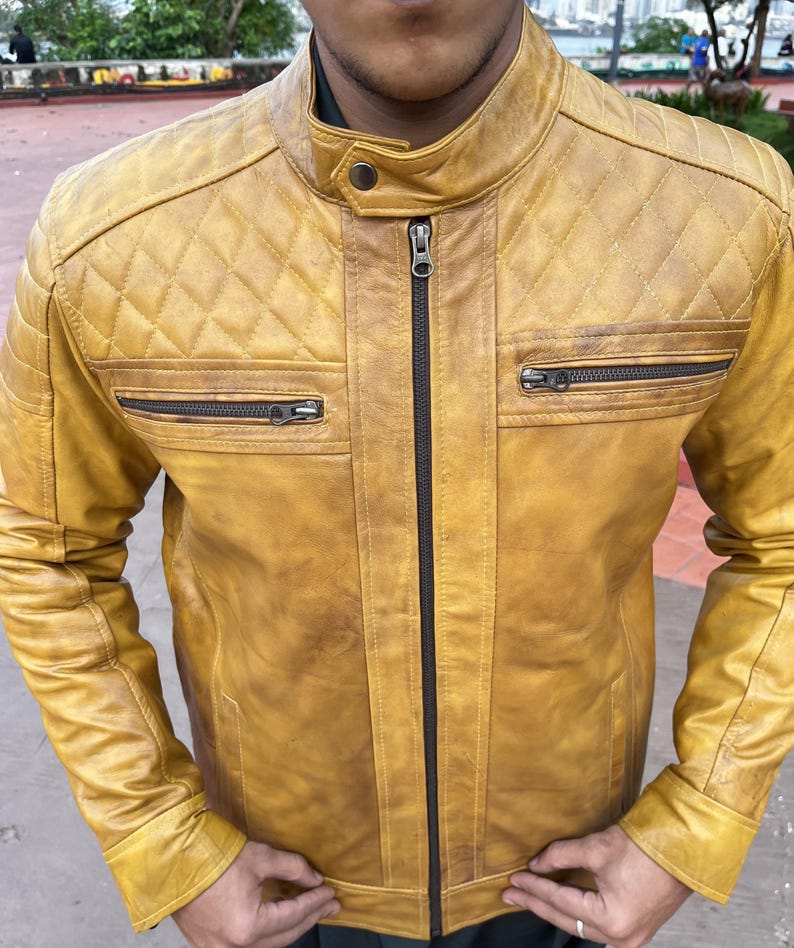 K&ouml;nnte beinhalten: Senfgelbe Lederjacke mit Steppdesign an den Schultern und zwei Brusttaschen mit Rei&szlig;verschluss. Die Jacke hat einen Stehkragen und einen durchgehenden Rei&szlig;verschluss. Das Leder hat ein Used-Look-Aussehen.