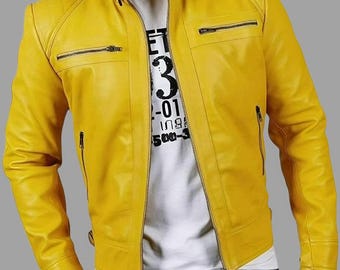May include: A bright yellow leather jacket with a stand-up collar and multiple zippered pockets. The jacket has a front zipper closure and is worn over a white t-shirt with black text. The model is wearing blue jeans.