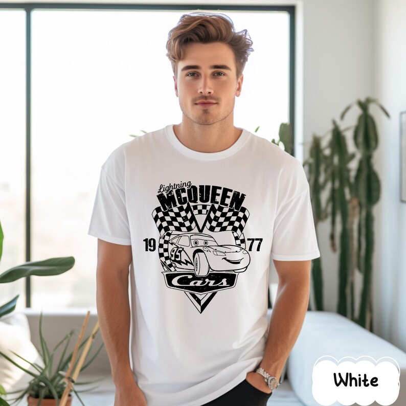 May include: White t-shirt with a black graphic of Lightning McQueen from the film Cars. The design includes a chequered flag, the number 95, and the text "Lightning McQueen" and "Cars". The shirt has a crew neck.