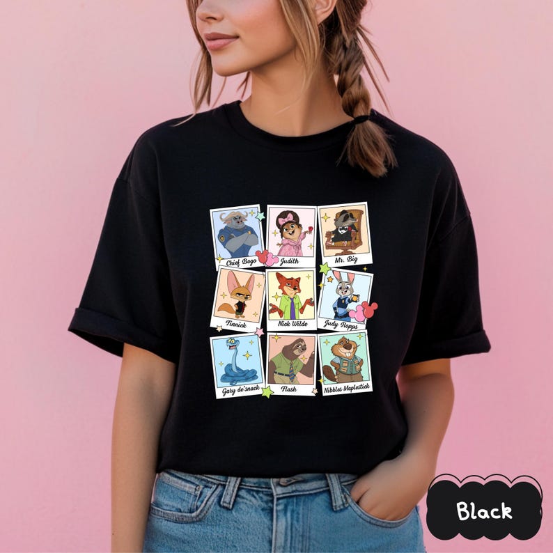 Peut inclure: T-shirt noir &agrave; col rond avec une grille de portraits de personnages de dessins anim&eacute;s. Chaque portrait porte le nom du personnage en dessous. Les personnages incluent Chief Bogo, Judith, Mr. Big, Finnick, Nick Wilde, Judy Hopps, Gary de' snack, Flash et Nibbles Maplestick.