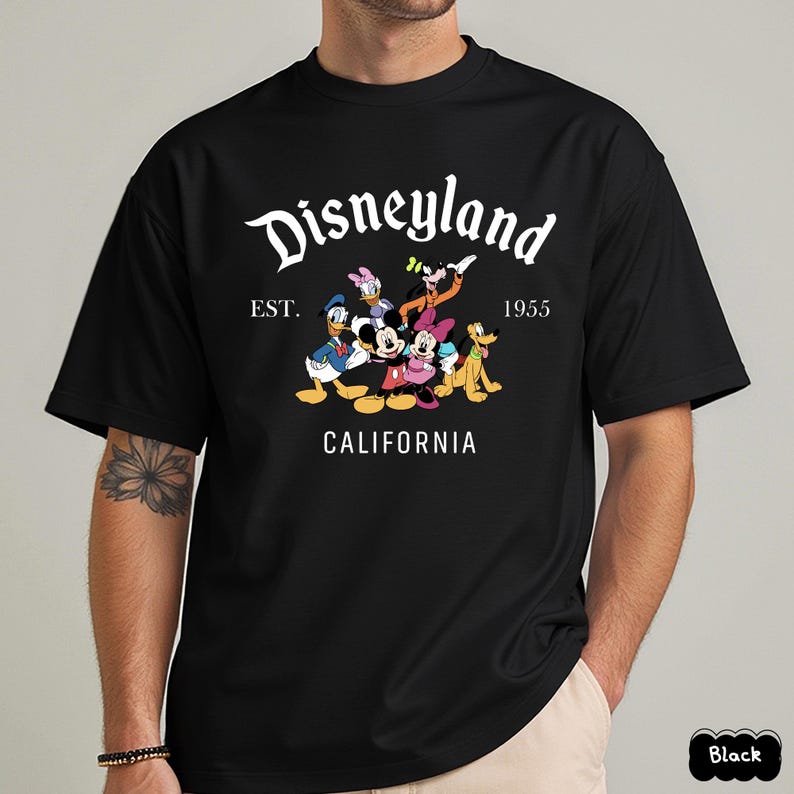 May include: Black t-shirt featuring a Disneyland graphic with Mickey Mouse, Minnie Mouse, Donald Duck, Daisy Duck, Goofy, and Pluto. The design includes the text "Disneyland" above "EST. 1955 CALIFORNIA".