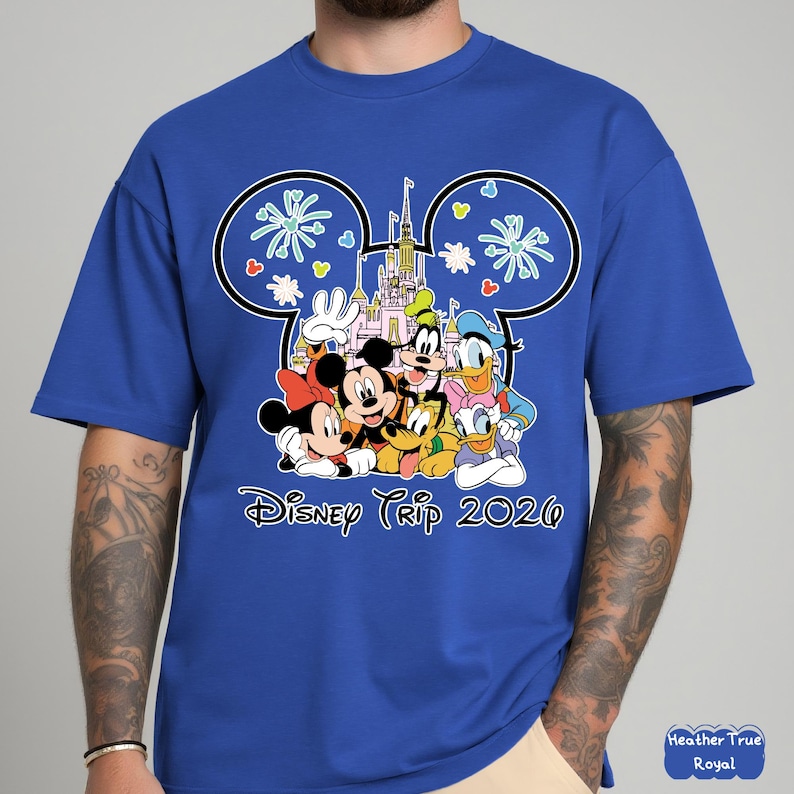 May include: Royal blue t-shirt featuring a graphic of Disney characters including Mickey and Minnie Mouse, Goofy, Donald and Daisy Duck. The design includes a castle and the text "Disney Trip 2020".