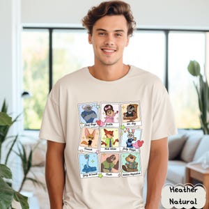 Peut inclure: Un t-shirt naturel chin&eacute; avec un graphisme color&eacute; de personnages de film. Le graphisme comprend des images de Chief Bogo, Judith, Mr. Big, Finnick, Nick Wilde, Judy Hopps, Gary de'snack, Flash et Nibbles Maplestick.