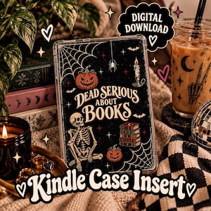 May include: A rectangular Kindle case insert featuring a black background with a skeleton sitting, two orange pumpkins, a stack of books, a lit candle, spiderwebs, and bats. The text reads Dead Serious About Books in a decorative font style.