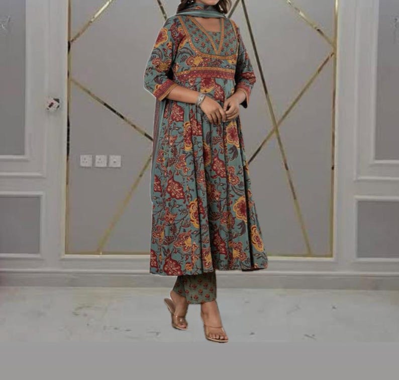 May include: A teal, floral-print ensemble featuring a long-sleeved tunic, matching pants, and a scarf. The tunic has a V-neckline and a flared silhouette. The floral pattern includes red and yellow accents. The outfit is suitable for casual or semi-formal occasions.