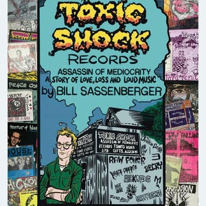 May include: A book cover for "Toxic Shock Records" by Bill Sassenberger, featuring a cartoon illustration. The title is in yellow and black, set against a blue background. The cover includes a drawing of a man and a building with the store's name.