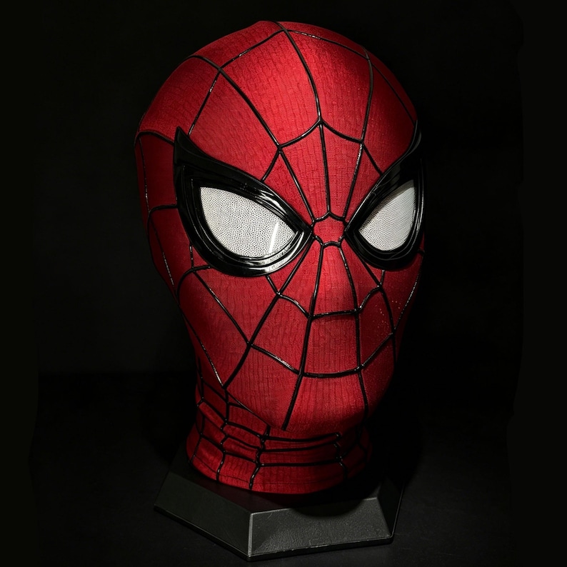 以下が含まれることがあります： 赤と黒のスパイダーマンマスク、クモの巣模様。 マスクには黒で縁取られた白いメッシュの目があり、黒いスタンドに展示されています。 マスクは頭全体を覆っています。