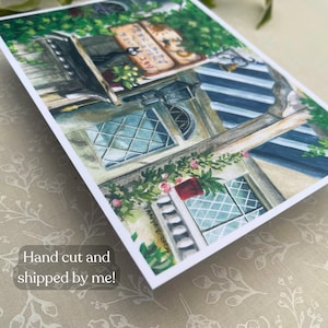 Pu&ograve; includere: Stampa ad acquerello di una facciata di un edificio con finestre, una tenda a strisce e piante rampicanti. L'opera presenta un'insegna con testo giapponese e una cassetta postale rossa. Il testo "Hand cut and shipped by me!" &egrave; visibile.