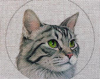 May include: A close-up of a gray tabby cat with green eyes. The cat is looking to the right of the image.