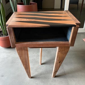 Walnut and black epoxy end table. Beautiful, unique side table with three tapered legs and storage.