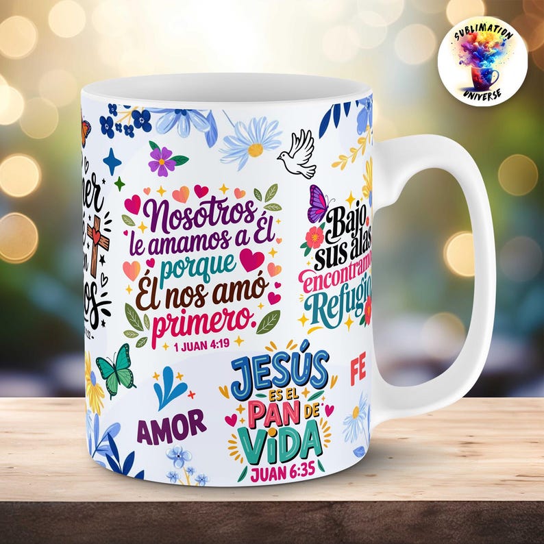 Pu&ograve; includere: Una tazza in ceramica bianca con un design colorato che avvolge l'intera superficie, caratterizzato da motivi floreali, farfalle e testi religiosi in spagnolo come "Nosotros le amamos a &Eacute;l porque &Eacute;l nos am&oacute; primero" e "Jes&uacute;s es el pan de vida".