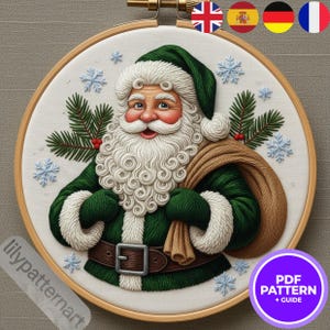 May include: Embroidered Santa Claus in a wooden hoop. Santa wears a green suit with white trim, a matching hat, and a long white beard. He carries a brown sack and is surrounded by snowflakes and pine branches. The text "PDF PATTERN + GUIDE" is in a purple circle.