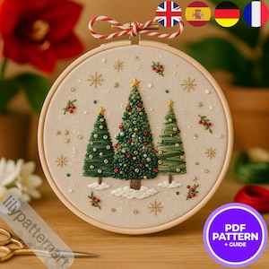 Peut inclure: Broderie de Noël dans un cercle en bois. Le motif présente trois sapins verts ornés de détails rouges et dorés, de flocons de neige et d'une étoile. Le fond est beige, et le cercle est noué avec une ficelle rouge et blanche. Le texte "PDF PATTERN + GUIDE" est visible.