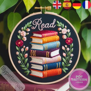 Pode incluir: Arte de bordado em bastidor com uma pilha de livros coloridos com a palavra "Read" bordada acima. O design inclui detalhes florais sobre um fundo azul escuro. Um padrão PDF e um guia estão incluídos.