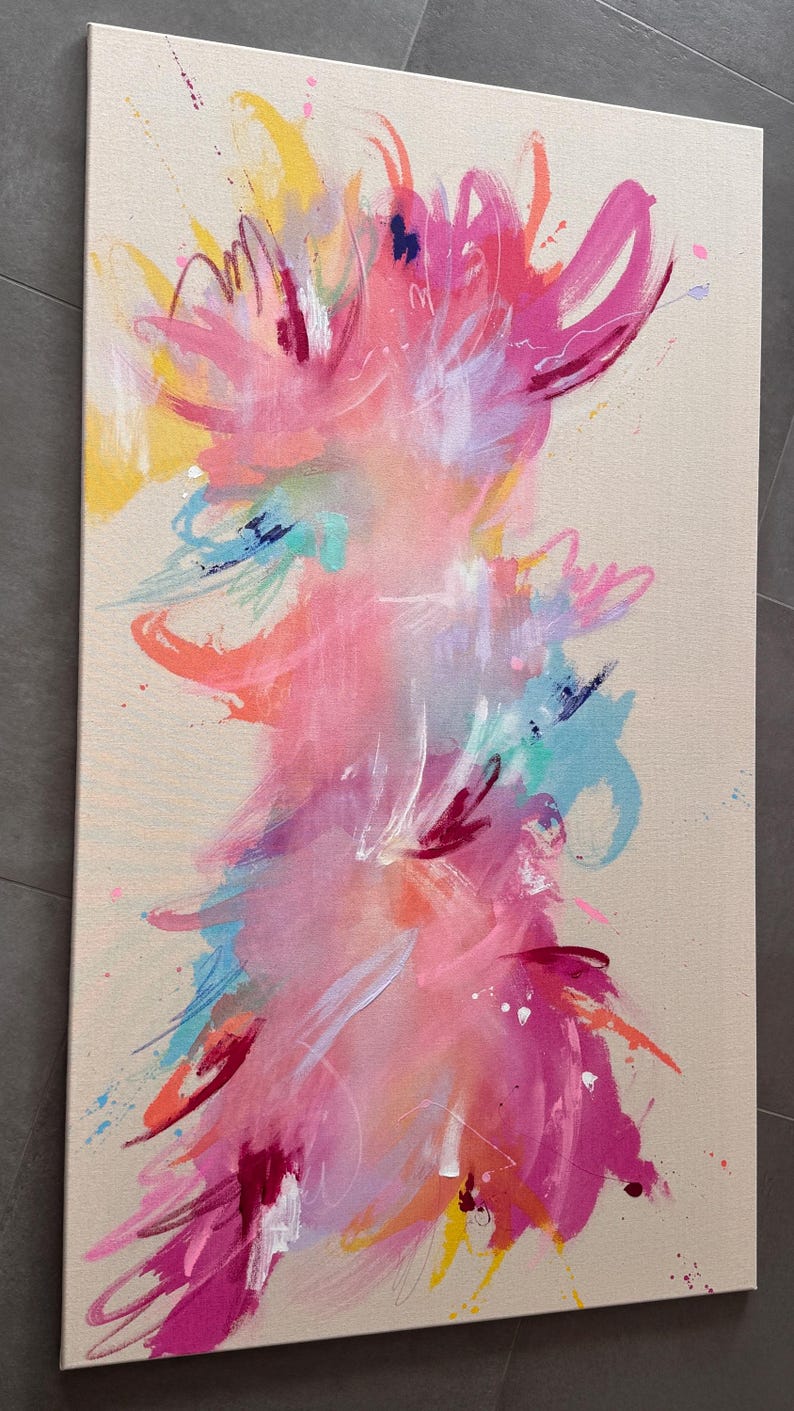 May include: A rectangular canvas painting featuring an abstract composition with vibrant splashes and brushstrokes of hot pink, magenta, orange, yellow, and light blue against a neutral beige background, creating a dynamic and layered visual effect.