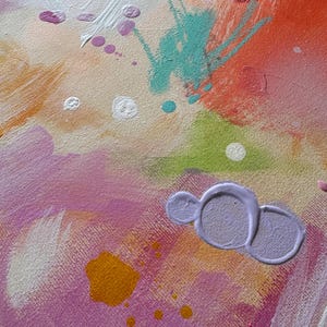 May include: An abstract painting on canvas featuring a vibrant color palette of pink, orange, lime green, and turquoise. The composition includes layered brushstrokes, paint splatters, and a distinct raised lavender paint mark in the lower section.