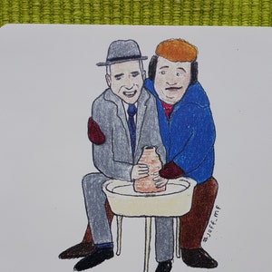 Può includere: Due uomini sono seduti a un tornio da vasaio, uno sta modellando un vaso di terracotta mentre l'altro guarda. La didascalia recita "Aerei, treni e ruote da vasaio".