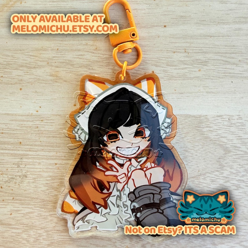 May include: A clear acrylic charm featuring an anime-style character with black hair, orange eyes, and a wide grin. The charm has an orange border and a gold-colored clasp. Text on the charm reads "ONLY AVAILABLE AT MELOMICHU.ETSY.COM" and "Not on Etsy? ITS A SCAM".