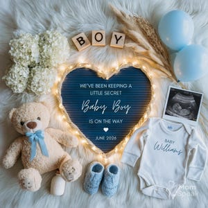 May include: An announcement with a blue heart-shaped sign, the word "BOY" in wooden blocks, and a teddy bear. The sign reads "Baby Boy is on the way, June 2026." A baby onesie says "Baby Williams."