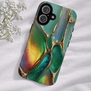 May include: A smartphone case with a vibrant, abstract design. The case features a blend of green, gold, and iridescent colors, with gold-colored vein-like accents. The case has a glossy finish and a camera cutout.