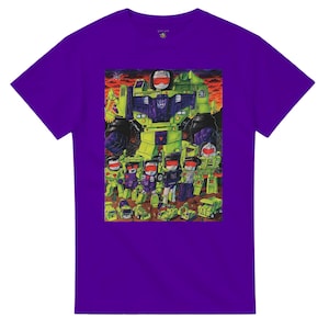 May include: A purple t-shirt featuring a colorful graphic of a group of robots. The robots are primarily green, purple, and red, with a large robot in the background. The shirt has a crew neck and short sleeves.