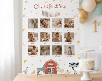 May include: A white photo display board titled "Olivia's First Year" with twelve photo slots, star accents, and a barn illustration. A small cake with a candle sits on a white cake stand. Balloons are in the background.