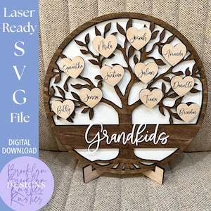 May include: A wooden family tree with the word "Grandkids" in white script. Heart-shaped name tags are attached to the tree branches. The words "Laser Ready SVG File DIGITAL DOWNLOAD" are on the left side.