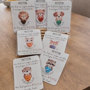 Könnte beinhalten: Eine Sammlung von Karten mit Tierillustrationen, darunter ein Löwe, ein Bär, ein Hund, eine Katze, ein Fuchs und ein Waschbär. Jede Karte trägt das Wort "MUTSTEIN" und deutschen Text. Die Karten haben eine transparente Kunststoffabdeckung.