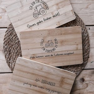 May include: Three rectangular bamboo cutting boards with engraved text and tractor illustrations. The text includes phrases like "I'm a village child" and "We are village children". The boards are arranged on a woven mat.