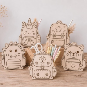 Könnte beinhalten: Schreibtisch-Organizer aus Holz in Form von Rucksäcken und Tieren, darunter ein Dinosaurier, ein Einhorn und ein Bär. Jeder Organizer hat ein anderes Design und fasst Stifte, Bleistifte und andere kleine Gegenstände. Hergestellt aus hellem Holz.