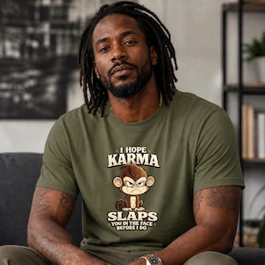 May include: Olive green t-shirt with the text "I Hope Karma Slaps You In The Face Before I Do" and a cartoon monkey illustration. The shirt is made of a soft material and has short sleeves.