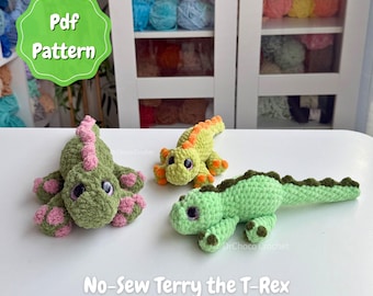May include: Three crocheted dinosaur toys labeled No-Sew Terry the T-Rex. One is olive green with pink accents, one is lime green with orange accents, and one is light green with dark green accents. Each has large dark eyes and a textured yarn finish.