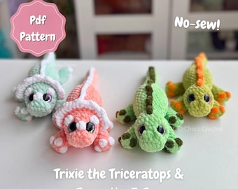 May include: Four crocheted dinosaur plushies including two triceratops in mint and coral with white frills, and two T-Rex figures in light green with dark green spots and yellow-green with orange spots. Text reads: Pdf Pattern, No-sew!, Trixie the Triceratops & Terry the T-Rex.