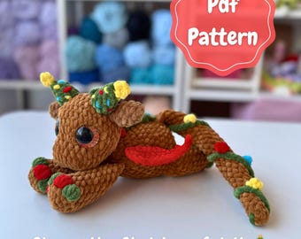 May include: A brown crocheted Christmas-themed creature with large black eyes, decorated with green, red, and yellow accents. The text "Pdf Pattern" is in a red bubble. The text "Ginger the Christmas Spirit" is below the creature.