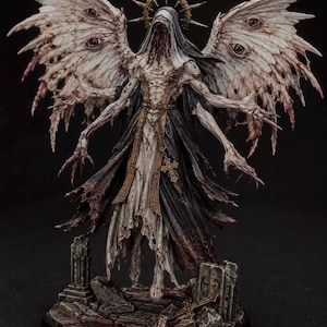 May include: A detailed figurine of a multi-winged, humanoid entity with a tattered white and black robe, a golden halo, and multiple eyes on its wings. The figure stands on a base of stone rubble with a cross, featuring a jagged, toothy maw.