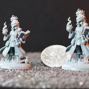 May include: Two unpainted gray resin miniature figures of a spellcaster wearing a long coat, goggles, and boots. Each figure holds an open book in one hand and a flame effect in the other, standing on a circular base next to a US quarter coin.