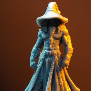 Könnte beinhalten: Eine graue Miniaturfigur aus Harz, die eine muskulöse Gestalt mit einem breitkrempigen Spitzhut und einem langen, gegürteten Mantel darstellt. Die Figur hat einen langen, geflochtenen Bart und definierte Bauchmuskeln und steht frontal.