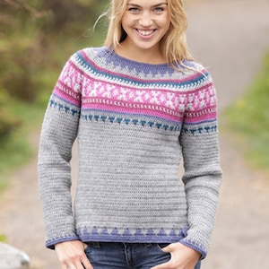 May include: A gray sweater with a round neck and long sleeves. The sweater features a patterned yoke with pink, blue, and white geometric designs. The cuffs and neckline are trimmed with a blue and purple border.